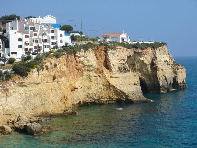turquoise sea below cliffs with ocean view terrace on top carvoeiro algarve portugal